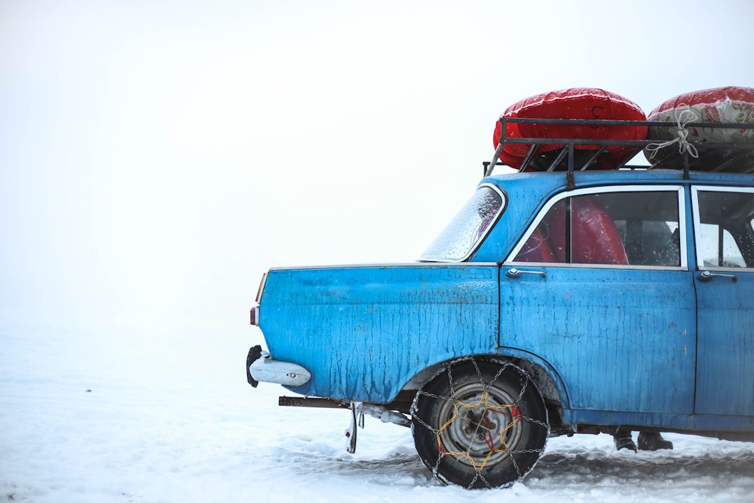 blue-sedan-with-chain-on-tire-parking-on-snowfield-at-daytime-wkklv0yqxts